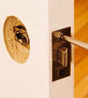 Hvordan du installerer en dørlås vedlagte mortise plate. Plasser låsen [eller bare innstikkslåsen plate] på plass på kanten av døren.