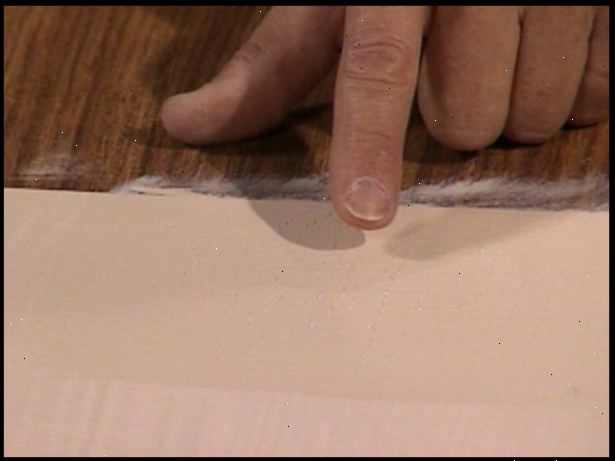 Hvordan å male melamin. Bruk 150 sandpapir til grov opp alle områder som du har tenkt å male.