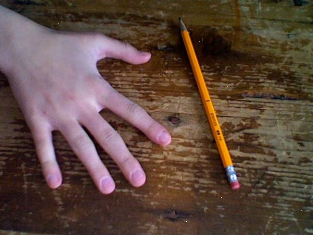 Hvordan å spinne en blyant rundt langfingeren. Hold blyanten slik du ville gjort når du skriver, bortsett plassere den mellom midten og ringfinger, ta tak i den i sentrum.