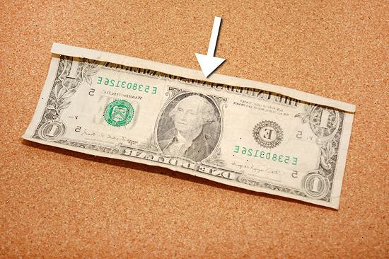 Hvordan å kaste en dollarseddel for å lage en finger ring. Plasser regningen på et flatt underlag, med forsiden opp.