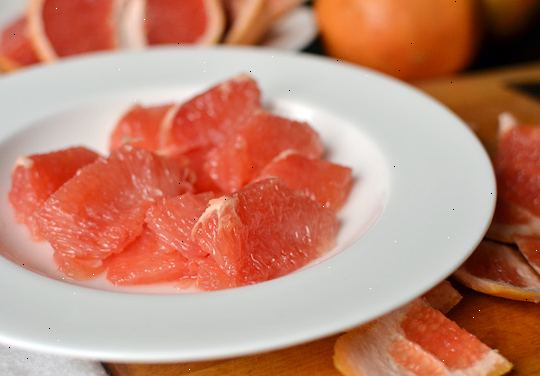 Hvordan å kutte en grapefrukt. Beskytt disken med en bred plate eller skjærebrett.