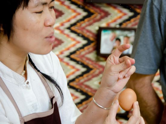Hvordan bryte en egg med en hånd. Plukk opp et egg og hold det med alle fingrene.
