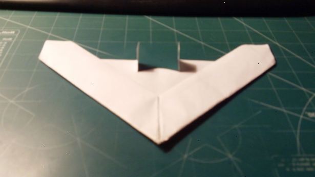 Hvordan lage en delta vinge papirfly. Krøll papiret for å finne sentrum.